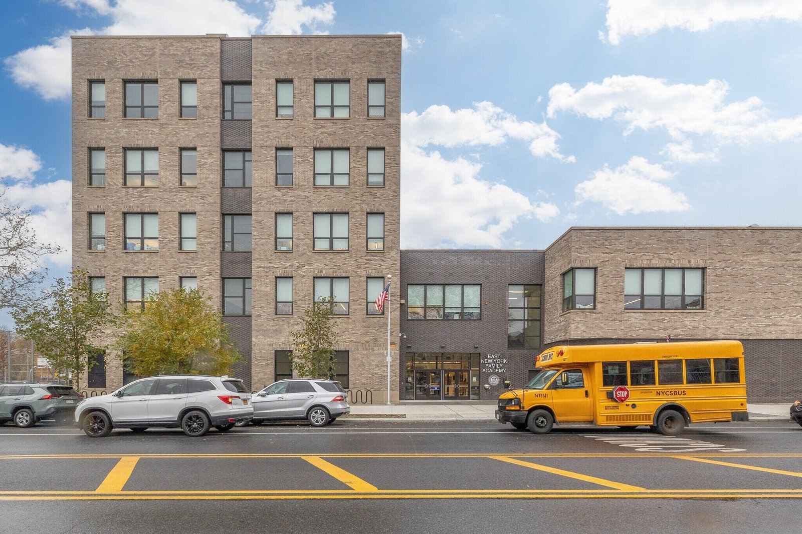 East New York Academy school building and NYC school bus, a completed municipal project supported by CPM Scheduling Consultants for on-time delivery.