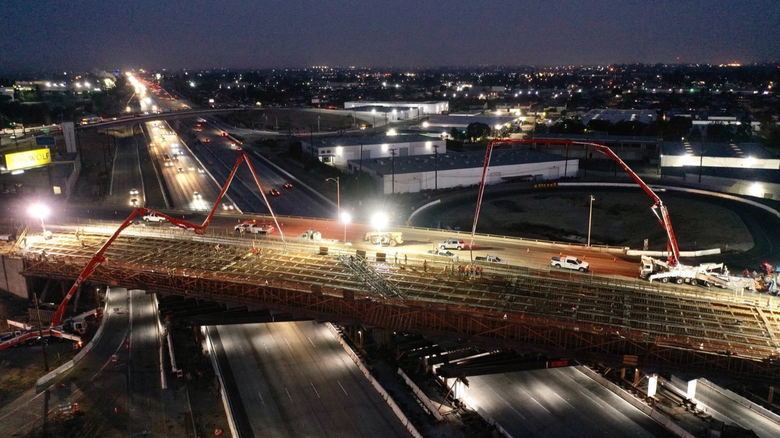 Construction company working on night-time bridge deck pour project