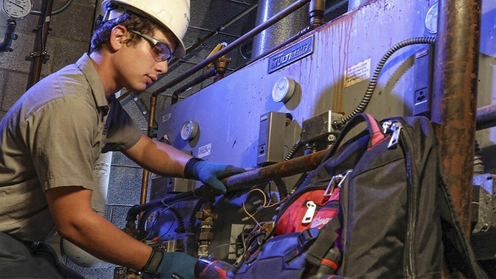 Construction company technician servicing HVAC mechanical system