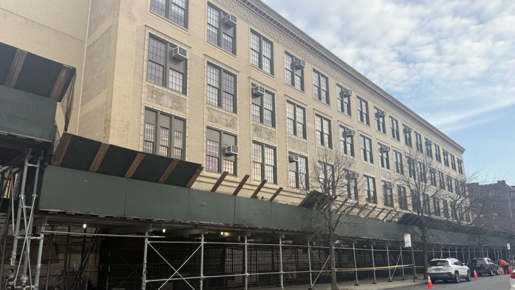 School building covered in scaffolding during updates tracked via CPM scheduling.