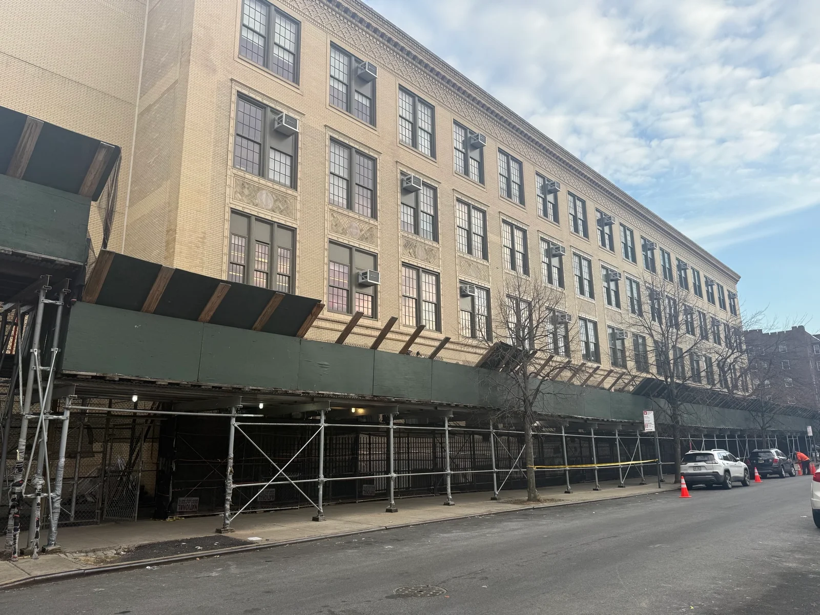 School building covered in scaffolding during updates tracked via CPM scheduling.